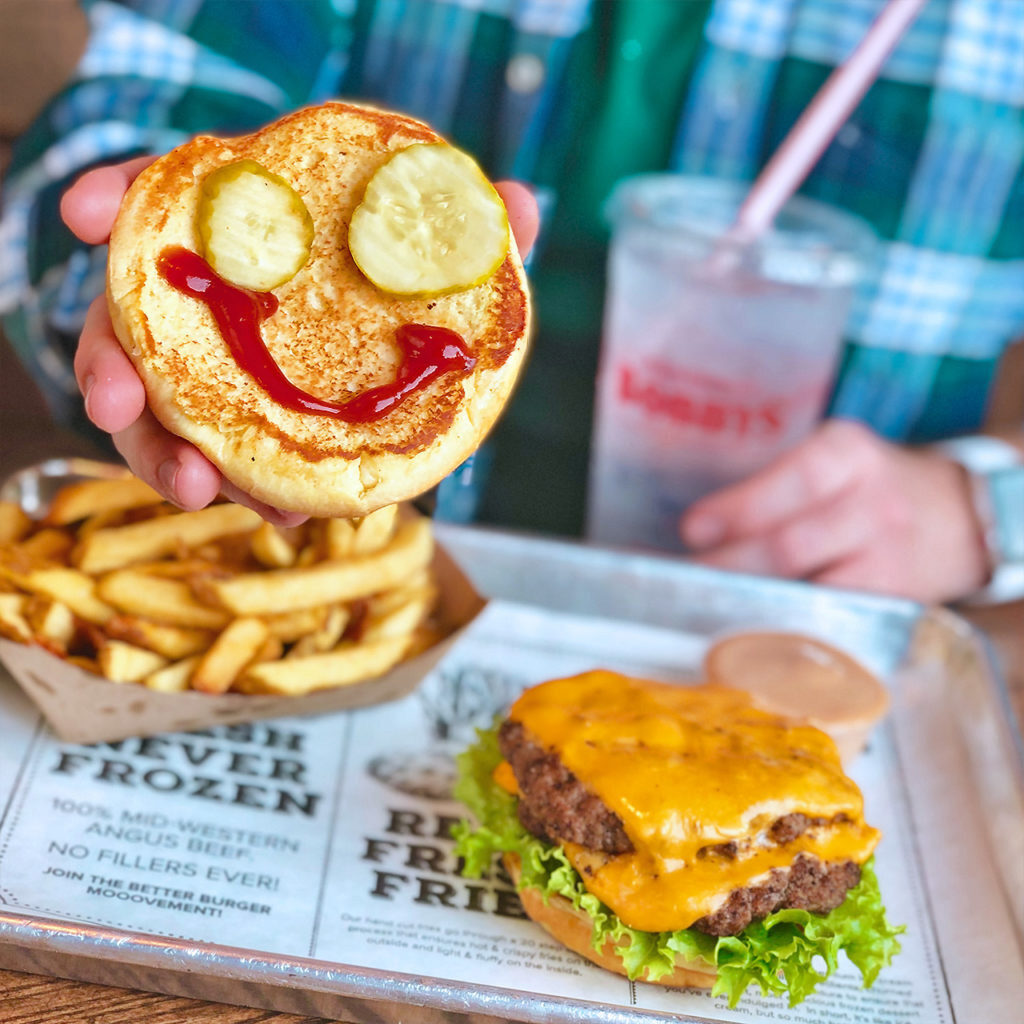 Hamburger bun with pickle eyes and ketchup smiley face